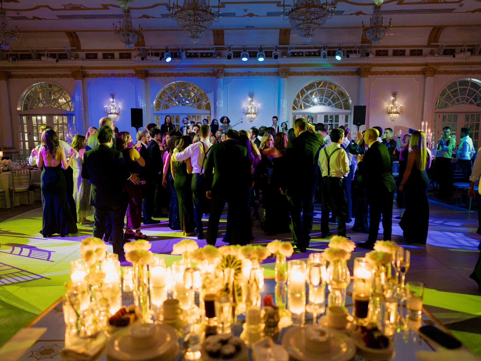 Guests dancing beside rows of candles on the reception floor