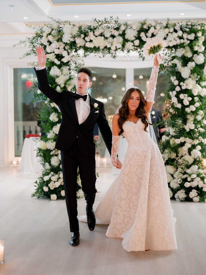 The couple making their entrance under the floral arch