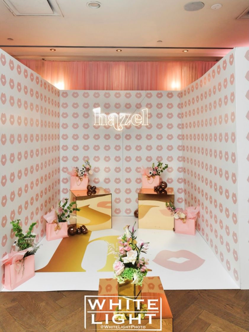 Photo room with pink lip-print walls and gold accents
