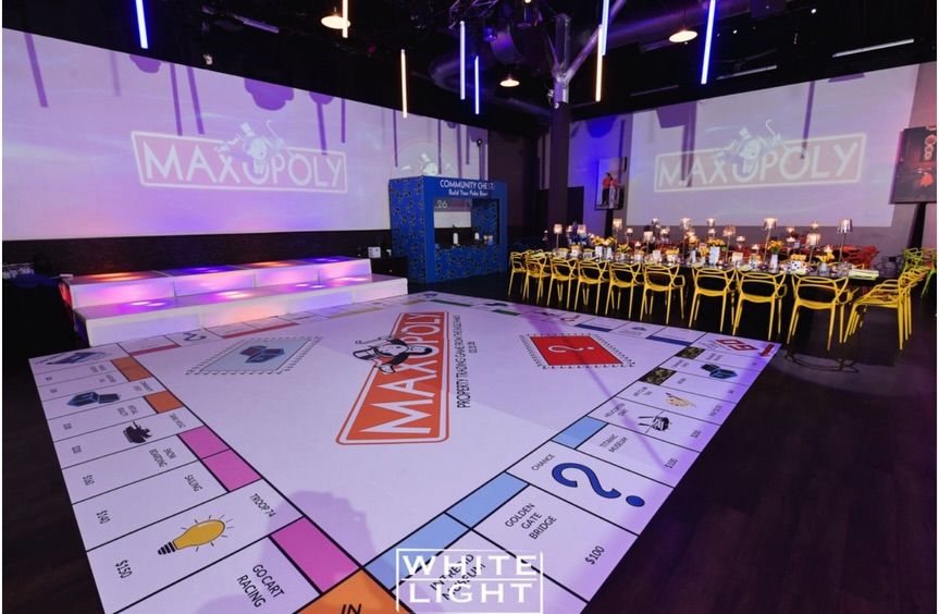 Dance floor printed as a giant game board with the party name projected on the wall