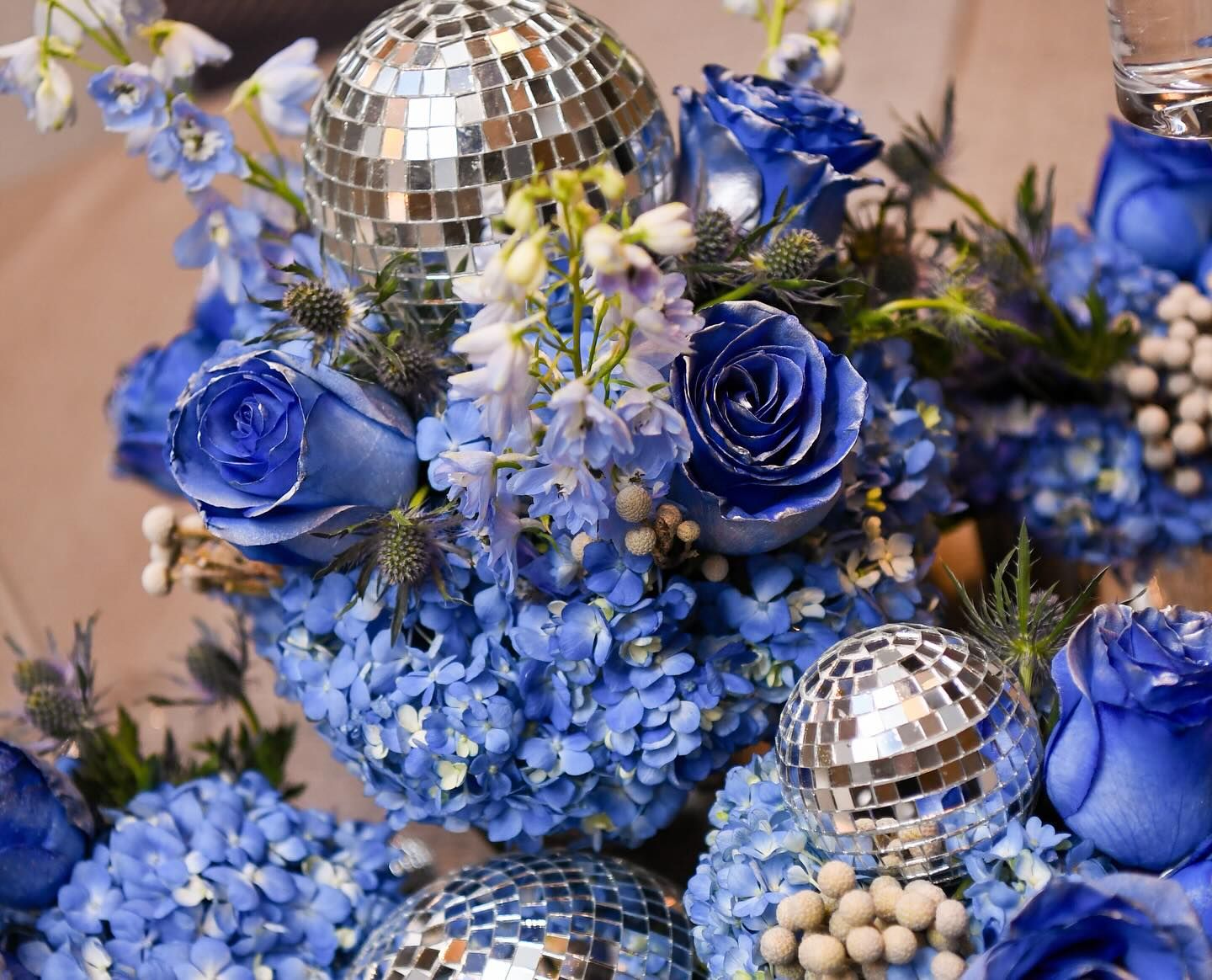 Centerpiece of blue roses, hydrangeas and mirrored disco balls