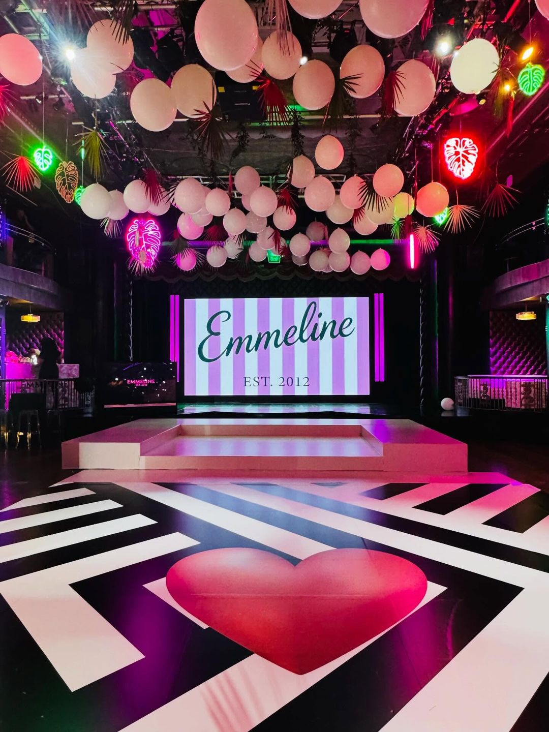 Black and white dance floor with a red heart under a ceiling of white balloons