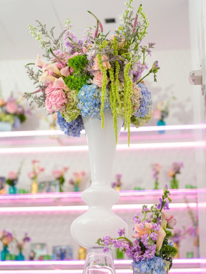 Tall floral centerpiece at a bat mitzvah in a white room