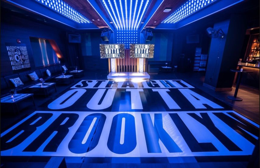 Dance floor printed with the words Straight Outta Brooklyn under blue lights