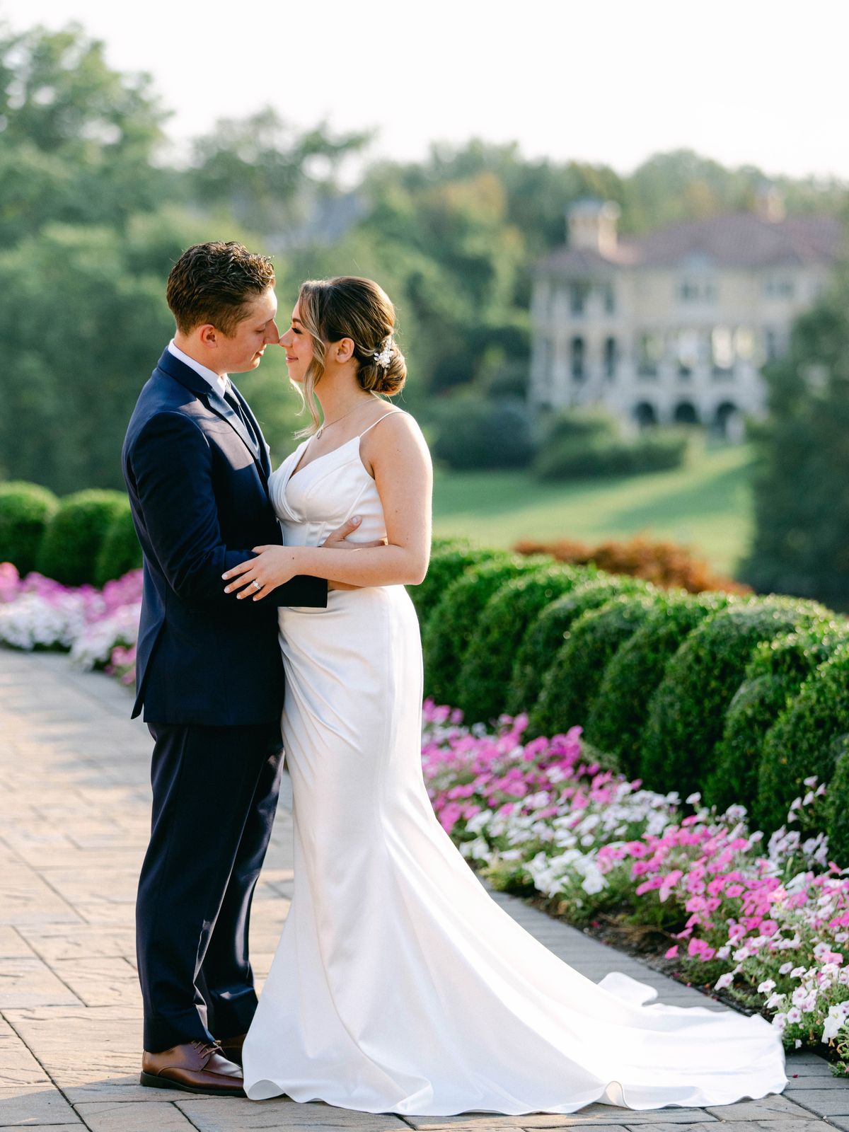 Couple embracing in a garden lined with pink flowers