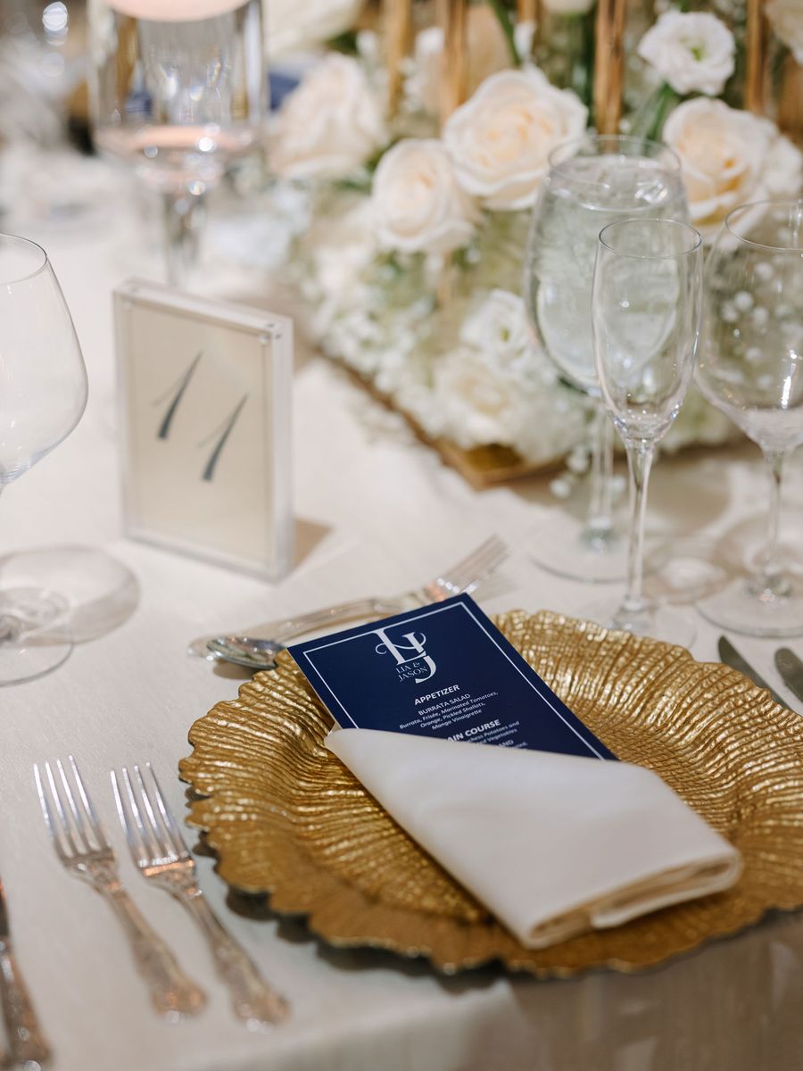 Place setting with a gold charger and a monogrammed menu card