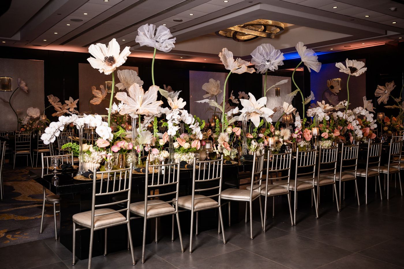 Long Sweet 16 table under giant paper flowers