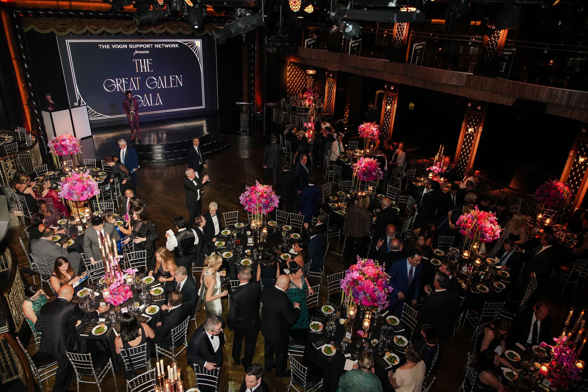 Edison Ballroom from above, full of gala guests at tables with tall pink centerpieces