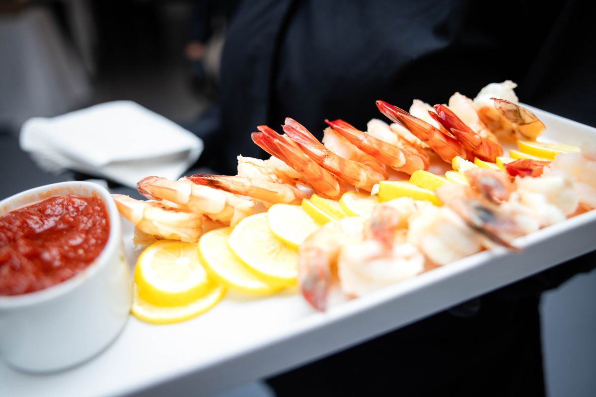 Passed tray of shrimp cocktail with lemon slices and cocktail sauce