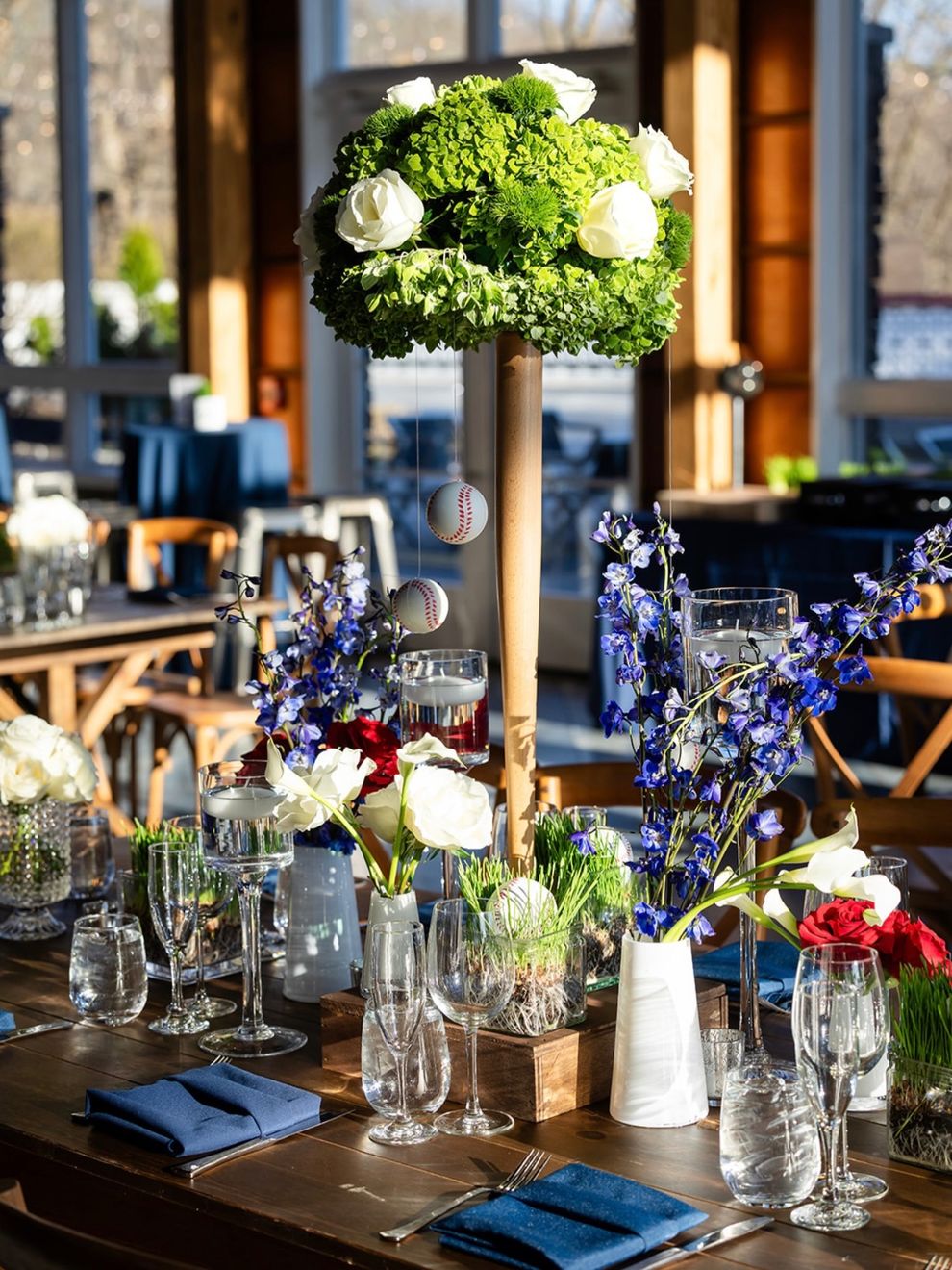 Centerpieces of green hydrangeas and blue flowers on wooden tables